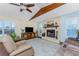 Living room with beautiful stone fireplace, wood beam, ceiling fan, and large windows at 1052 Newton St, Englewood, FL 34224