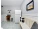 Utility room area with a white refrigerator, seating, and decor at 1052 Newton St, Englewood, FL 34224