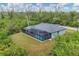 Aerial view showcasing a private backyard, screened pool, and surrounding green space at 10782 Kearsarge Cir, Port Charlotte, FL 33981