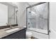Modern bathroom featuring granite vanity, tile flooring, and a glass-enclosed shower with marble-patterned tile surround at 10782 Kearsarge Cir, Port Charlotte, FL 33981