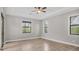 Spacious bedroom with a ceiling fan, tray ceiling, and large windows offering natural light at 10782 Kearsarge Cir, Port Charlotte, FL 33981