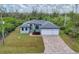 Exterior view of a well-maintained home with a three-car garage, a brick-paved driveway, and a verdant lawn at 10782 Kearsarge Cir, Port Charlotte, FL 33981