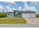 Modern home with a three-car garage and a brick-paved driveway, set on a well-manicured lawn at 10782 Kearsarge Cir, Port Charlotte, FL 33981