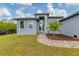 Charming home front entrance with brick walkway, lush lawn, and freshly mulched palm tree bed at 10782 Kearsarge Cir, Port Charlotte, FL 33981