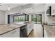 Open kitchen with an island, stainless appliances, and view of screened pool and lanai through sliding doors at 10782 Kearsarge Cir, Port Charlotte, FL 33981