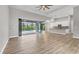 Open-concept living area with wood-look floors and sliding glass doors to a screened lanai and pool at 10782 Kearsarge Cir, Port Charlotte, FL 33981