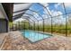 Screened-in pool with brick pavers and a lush backyard at 10782 Kearsarge Cir, Port Charlotte, FL 33981