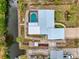 Overhead view of the home with a metal roof, screened pool, dock, and lush landscaping at 1173 Brown St, Englewood, FL 34224