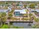 An aerial view features a cheerful yellow home with a screened pool and canal access at 1173 Brown St, Englewood, FL 34224