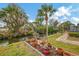 Manicured back yard with lush vegetation, potted plants, and canal access at 1173 Brown St, Englewood, FL 34224