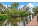 View of the tranquil canal bordered by lush greenery and a wooden dock at 1173 Brown St, Englewood, FL 34224