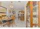 Inviting dining area with a round wooden table, elegant light fixture, and decorative seashell display cabinet at 1173 Brown St, Englewood, FL 34224