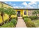 Welcoming yellow home with a stone accent wall, well-maintained landscaping, and a charming front entrance at 1173 Brown St, Englewood, FL 34224