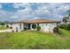 Inviting single-story home with a well-maintained lawn, screened-in porch, and tidy landscaping at 12 Charleston Cir, Englewood, FL 34223