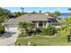 An elevated view of the home, highlighting the lush landscaping, circular driveway, and solar panels at 12432 Nova Ave, Port Charlotte, FL 33981