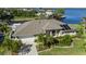 Aerial view of a home near the water with solar panels, a well manicured lawn, and lush landscaping at 12432 Nova Ave, Port Charlotte, FL 33981