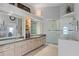 Bathroom with double vanity sinks, granite countertop, and walk-in shower with glass door at 12432 Nova Ave, Port Charlotte, FL 33981