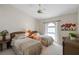 Serene bedroom featuring two twin beds, soft lighting, and an arched window for natural light at 12432 Nova Ave, Port Charlotte, FL 33981