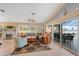 Bright living room featuring neutral colors, tile flooring, a ceiling fan, and sliding glass doors to the lanai at 12432 Nova Ave, Port Charlotte, FL 33981
