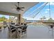 Screened-in patio with ceiling fan and dining area overlooking the pool and waterfront view at 12432 Nova Ave, Port Charlotte, FL 33981