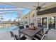 Covered patio with dining furniture overlooking the pool and waterfront at 12432 Nova Ave, Port Charlotte, FL 33981