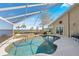 Enjoy the screened pool and spa with beautiful waterfront views and lush landscaping at 12432 Nova Ave, Port Charlotte, FL 33981