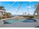 A screened in pool features a waterfall, with beautiful views of the water at 12432 Nova Ave, Port Charlotte, FL 33981