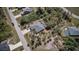 Aerial view of the property and landscaping, featuring a screen enclosed pool and a grey shingle roof at 127 Linda Lee Dr, Rotonda West, FL 33947