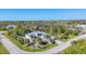 Aerial view of a well-maintained home featuring a screened-in pool, palm trees, and lush landscaping at 13379 Journal Ln, Port Charlotte, FL 33981
