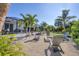 A backyard with a firepit and adirondack chairs alongside a screened-in pool and tropical landscaping at 13379 Journal Ln, Port Charlotte, FL 33981