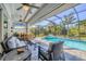 Screened lanai with a well-appointed sitting area and a beautiful pool and spa surrounded by tropical landscaping at 13379 Journal Ln, Port Charlotte, FL 33981