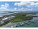 Stunning aerial view of waterfront condos, a marina with boat lifts, and a scenic coastal landscape at 1420 Beach Rd # 203, Englewood, FL 34223