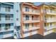 Condominium complex featuring private balconies, stairways, and colorful exterior at 1420 Beach Rd # 203, Englewood, FL 34223