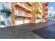 Condominium exterior with balconies, garage doors, stairs, and colorful facade at 1420 Beach Rd # 203, Englewood, FL 34223