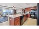 Bright, open kitchen with granite island and seating, seamlessly flowing into a living and dining area at 1420 Beach Rd # 203, Englewood, FL 34223