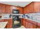Modern kitchen with granite countertops, stone backsplash, and stainless steel appliances with dark wood cabinetry at 1420 Beach Rd # 203, Englewood, FL 34223