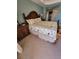 This main bedroom includes a large bed and bedside table with lamp at 1420 Beach Rd # 203, Englewood, FL 34223