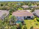 Aerial view showcasing a home's screened pool, lush landscaping, and well-maintained lawn at 14270 Reserve Ct, Port Charlotte, FL 33953