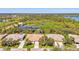 Scenic aerial view of community homes near a lake, featuring lush landscaping and mature trees at 14270 Reserve Ct, Port Charlotte, FL 33953