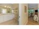 Bright bathroom with double vanity sinks, and doorway views into the bedroom at 14270 Reserve Ct, Port Charlotte, FL 33953