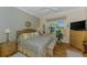 Comfortable bedroom boasts light walls, wood floors, and a large window with tranquil views at 14270 Reserve Ct, Port Charlotte, FL 33953