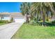 Charming home with a well-manicured lawn, mature palm trees, and a two-car garage at 14270 Reserve Ct, Port Charlotte, FL 33953
