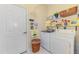 A bright laundry room featuring a washer, a dryer, shelving, and a door at 14270 Reserve Ct, Port Charlotte, FL 33953