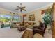 Bright living room featuring ample seating, a ceiling fan, and a view of the outdoor patio at 14270 Reserve Ct, Port Charlotte, FL 33953