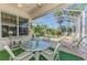 A screened patio featuring outdoor furniture, ceiling fan, and picturesque view of the pool and landscaping at 14270 Reserve Ct, Port Charlotte, FL 33953