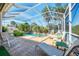 An inviting pool with lush landscaping, a waterfall feature, and comfortable lounge chairs for relaxation at 14270 Reserve Ct, Port Charlotte, FL 33953