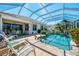 Inviting screened-in pool with lush landscaping, patio chairs, and an outdoor dining area at 14270 Reserve Ct, Port Charlotte, FL 33953