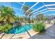 Beautiful pool surrounded by lush landscaping within a screened enclosure providing privacy and shade at 14270 Reserve Ct, Port Charlotte, FL 33953