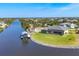 Wide aerial view of waterfront home with screened-in pool and private boat dock along a scenic canal at 14286 Fort Worth Cir, Port Charlotte, FL 33981
