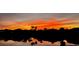 An orange sunset beautifully reflects across the pond behind the property at 14286 Fort Worth Cir, Port Charlotte, FL 33981